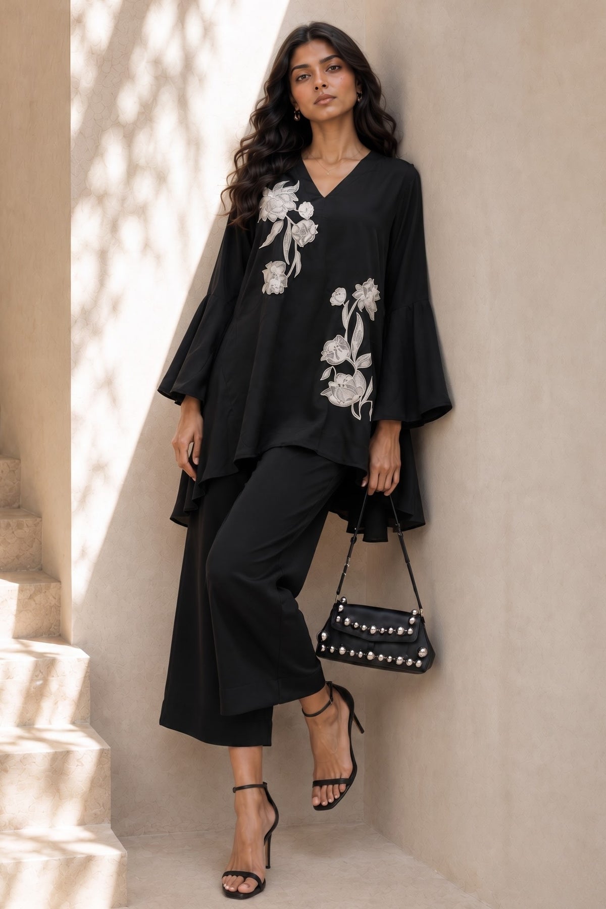 Woman wearing a black women co ord set, an embroidered kurta with wide-leg pant in natural crape, full-length front view.