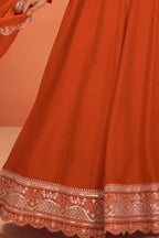 Waist-down detail view of a neon orange anarkali for wedding outfit in premium silk with sequin embroidered flared skirt hem.