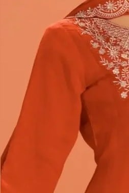 Close-up of the neckline embroidery on a neon orange georgette anarkali dress in premium silk with sequin and thread work.