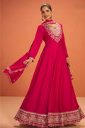 Woman wearing a pinkish red anarkali dress for wedding in premium silk with sequin and thread embroidery and silk dupatta, full-length front view.