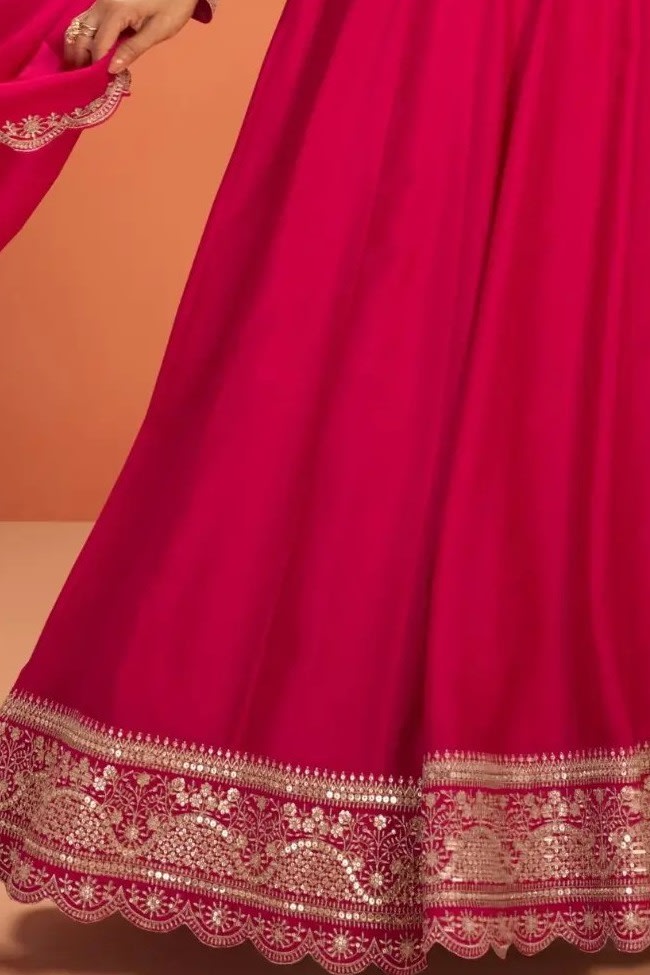 Waist-down detail view of a pinkish red anarkali dress for women in premium silk with sequin embroidered flared skirt hem.