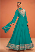 Woman wearing a teal party wear anarkali gown in premium silk with sequin and thread embroidery and silk dupatta, full-length front view.