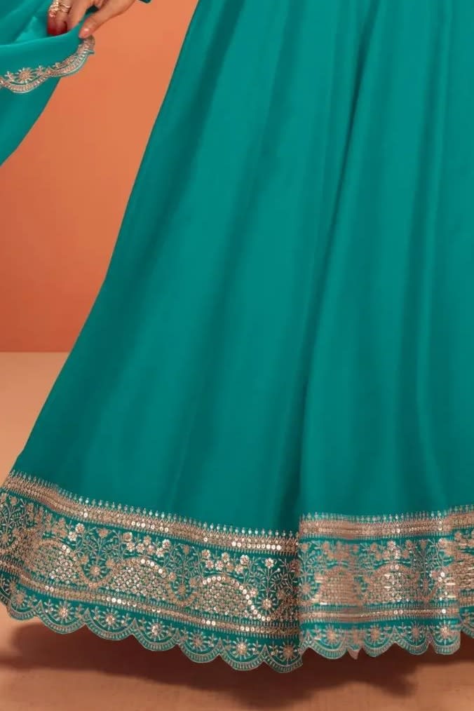 Waist-down detail view of a teal silk anarkali gown in premium silk with sequin and thread embroidered flared skirt hem.