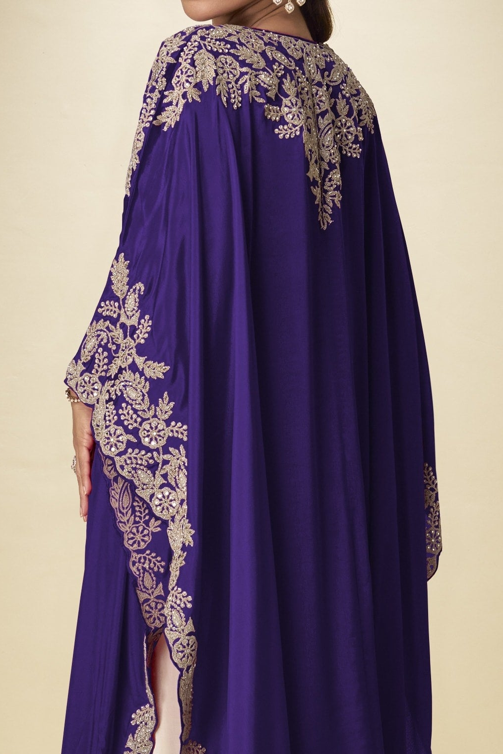 Back close-up view of a purple plazo with suit outfit showing gold embroidery detail across the cape shoulders and long sleeves.