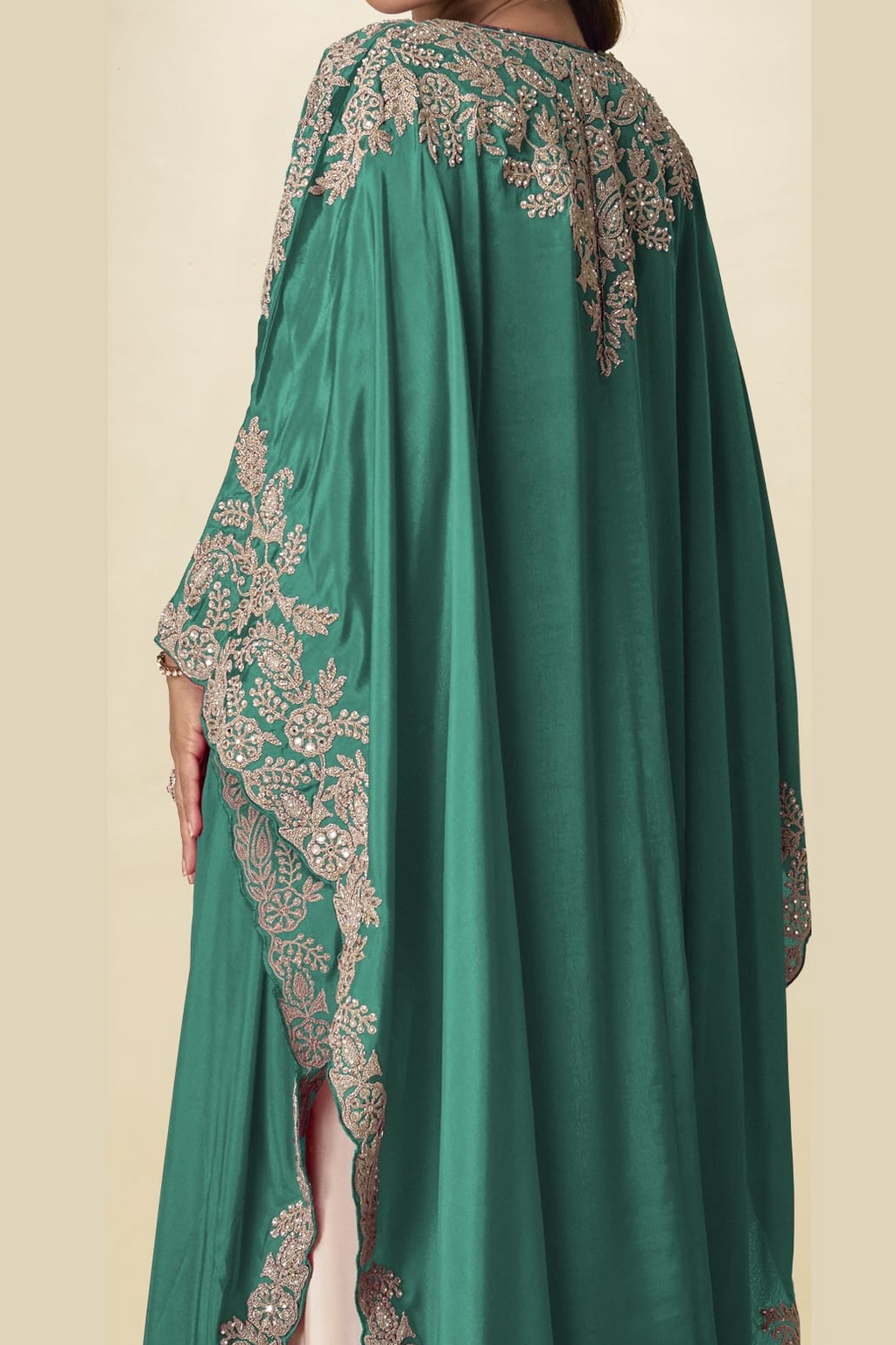 Back close-up view of a green palazzo salwar suit outfit showing detailed gold embroidery on the cape shoulders and side sleeves.