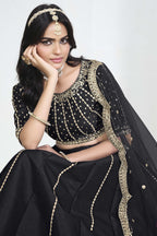 Close-up view of a black lehenga with mirror work showing detailed mirror, sequin and thread work on the art silk choli.