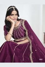 Close-up view of a wine purple wedding lehenga showing detailed mirror, sequin and thread work on the art silk choli. All-over mirror work.