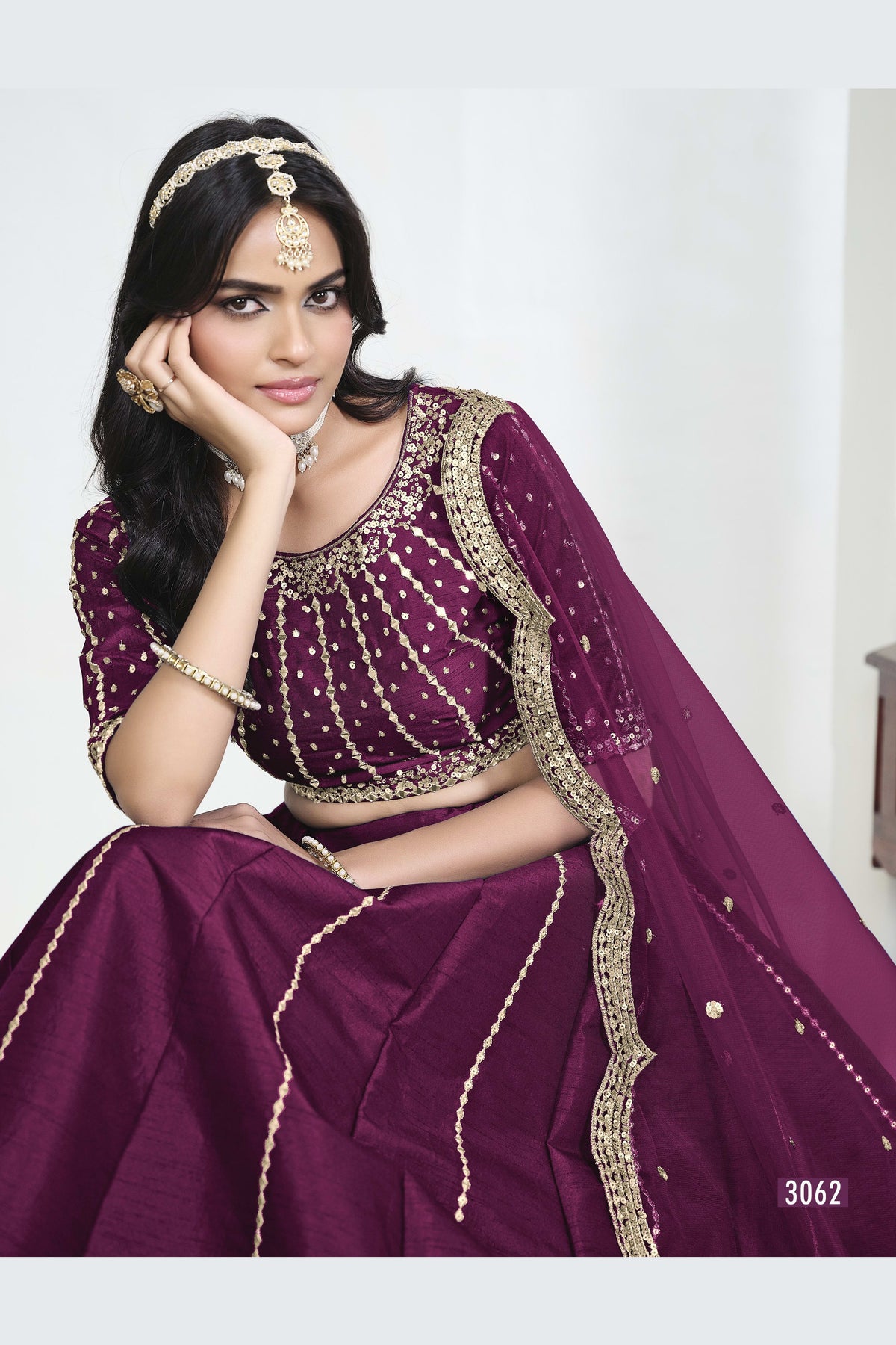 Close-up view of a wine purple wedding lehenga showing detailed mirror, sequin and thread work on the art silk choli. All-over mirror work.