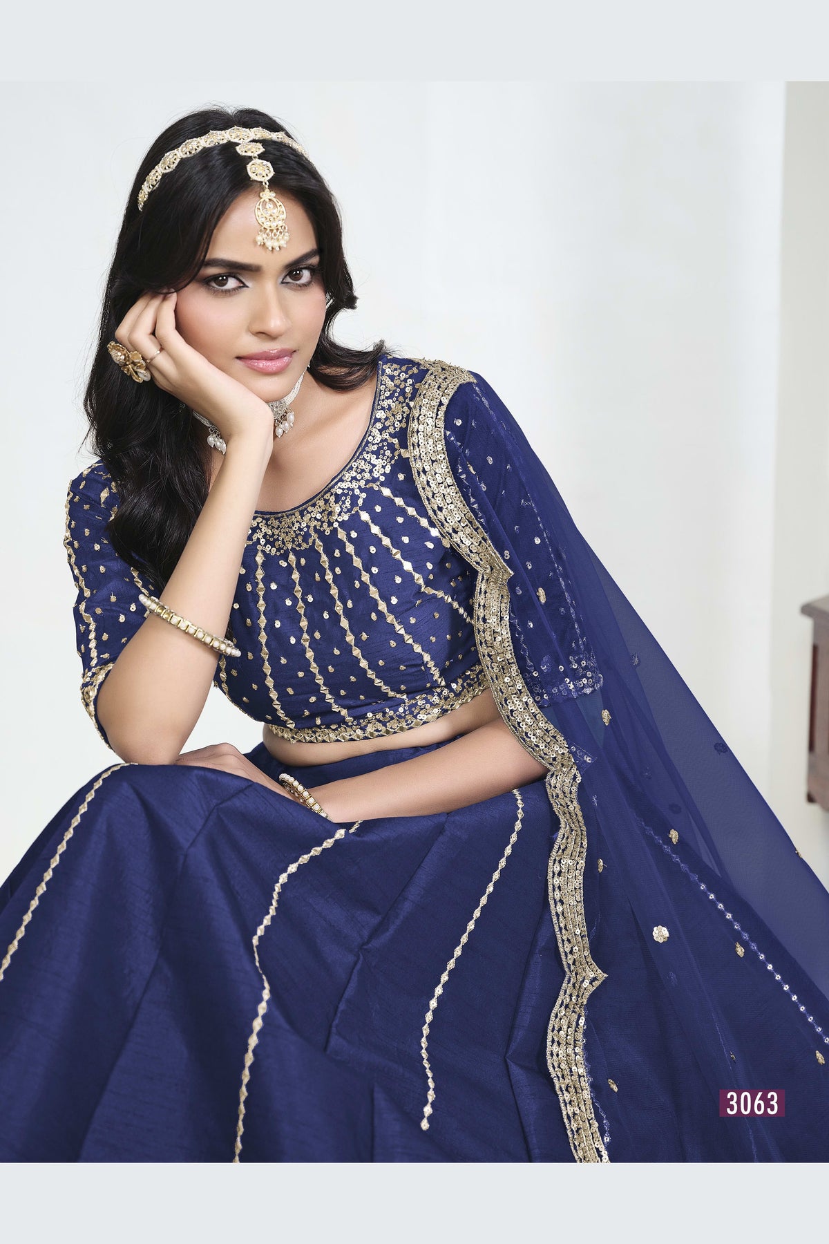 Close-up view of a navy blue lehenga with mirror work showing detailed mirror, sequin and thread work on the art silk choli.