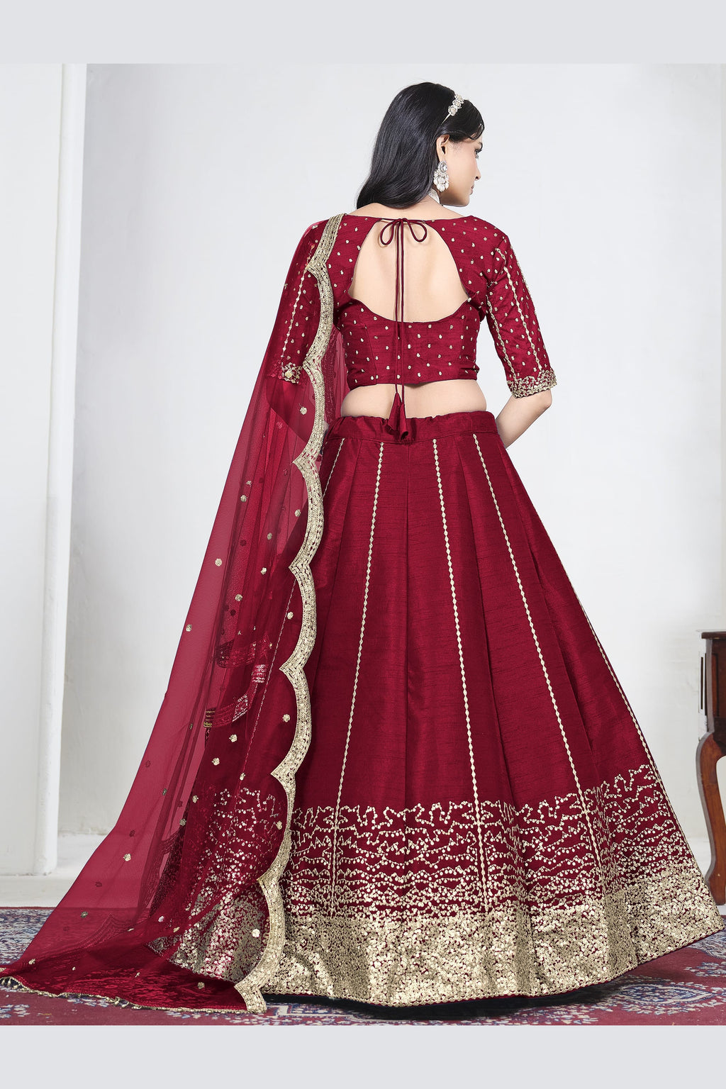 Full-length back view of a red wedding lehenga with an open back choli with dori tie and mirror work on the back. All-over mirror work.