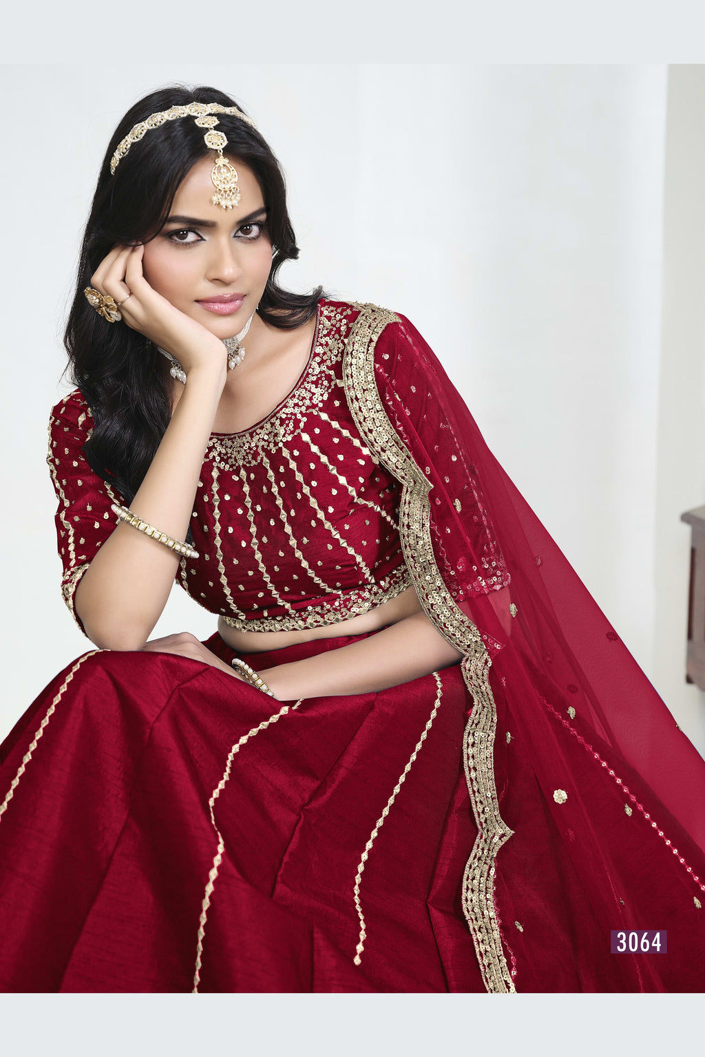 Close-up view of a red lehenga with mirror work showing detailed mirror, sequin and thread work on the art silk choli. All-over mirror work.