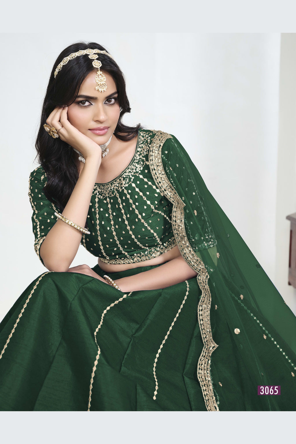 Close-up view of a green lehenga with mirror work showing detailed mirror, sequin and thread work on the art silk choli.