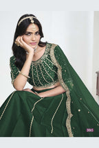 Close-up view of a green lehenga with mirror work showing detailed mirror, sequin and thread work on the art silk choli.
