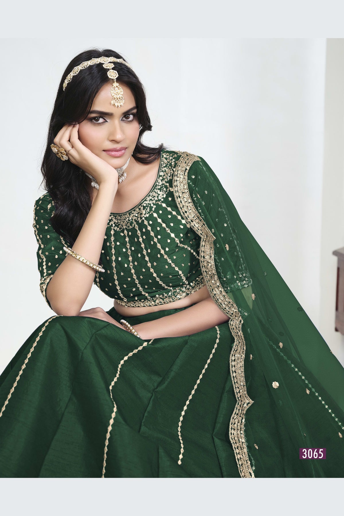 Close-up view of a green lehenga with mirror work showing detailed mirror, sequin and thread work on the art silk choli.