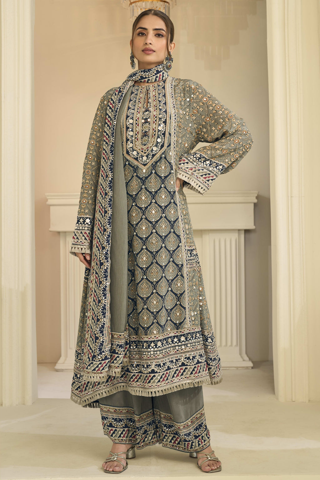 Woman wearing greenish grey indian wedding guest dresses style plazo suit in crepe silk with hand aari work and gota patti work, printed plazo and dupatta, full-length front view.