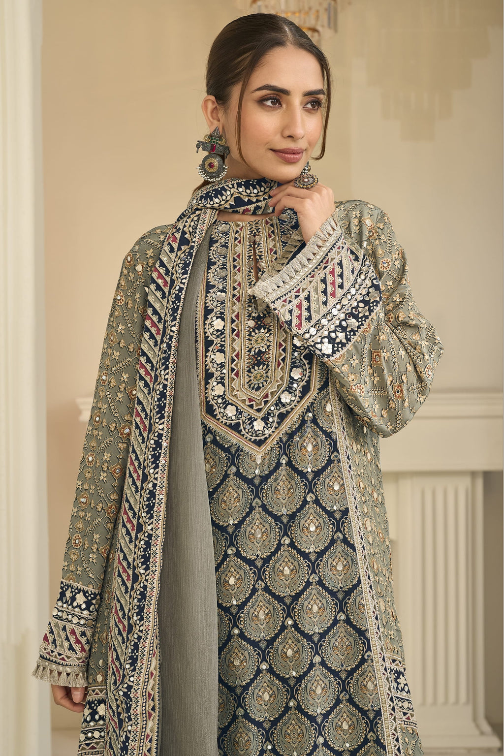 Close-up of a greenish grey palazzo suit bodice in crepe silk with hand aari work and gota patti work on the neckline and three-quarter sleeves.