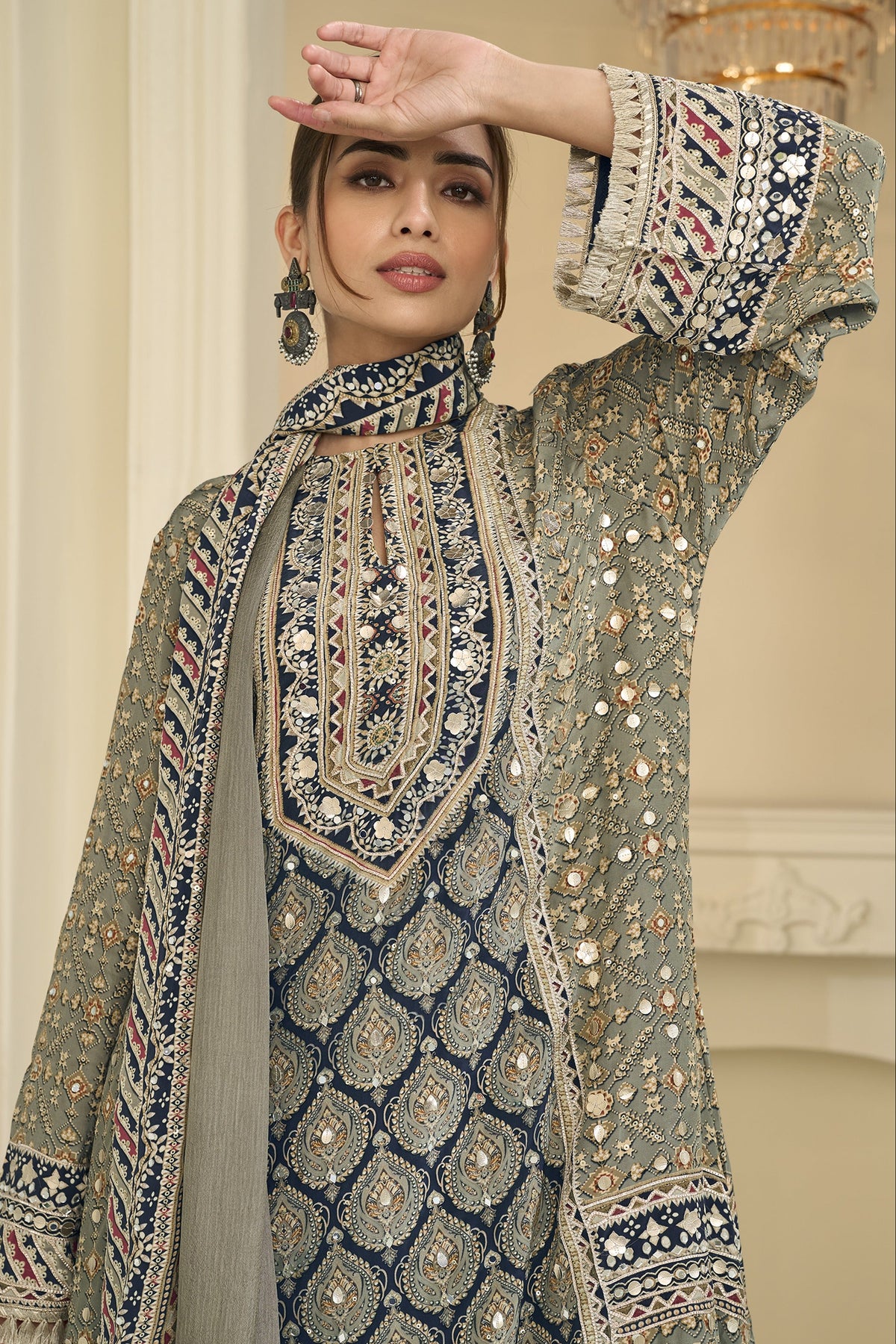 Close-up of a greenish grey palazzo suit bodice in crepe silk with hand aari work and gota patti work on the neckline and three-quarter sleeves.