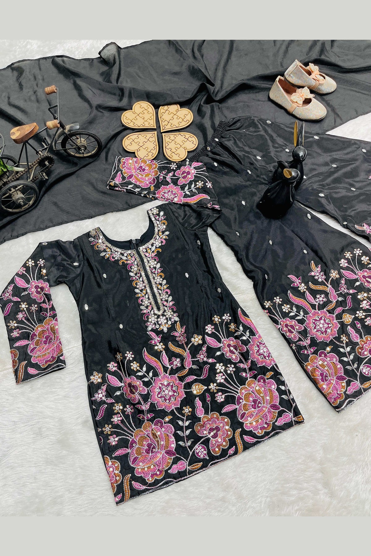 Black kids plazo suit flat lay detail, close-up of pink floral sequin and thread work on the chinon silk kameez.