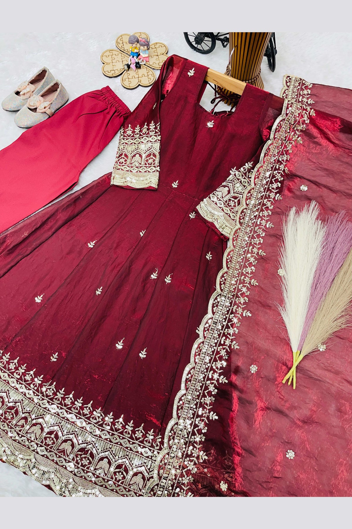 Maroon girls anarkali suit on model, side view displaying the flared anarkali silhouette with sequin work.