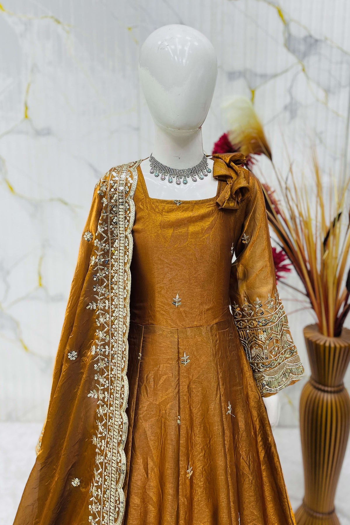 Close-up of mustard anarkali bodice, sequins and zari embroidery on fendy silk fabric.