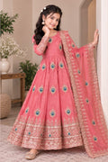 Girl wearing a coral pink indian kidswear anarkali set, close full-length view of the embroidered gown and dupatta.