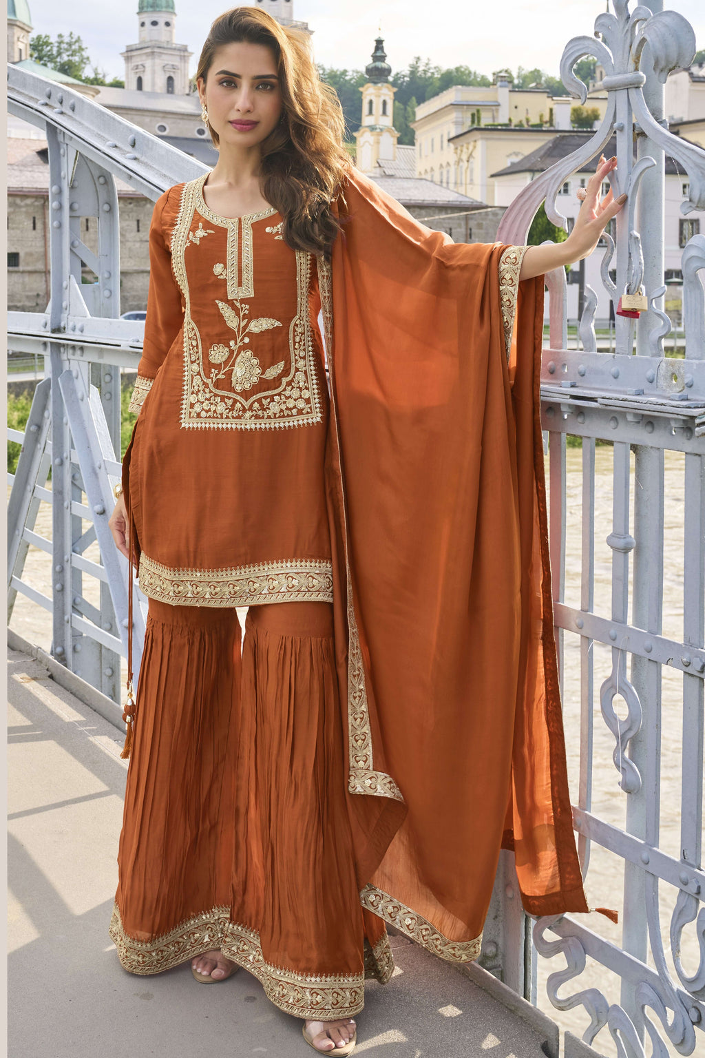 Rust sharara suit with embroidery work on pure silk, shown in a full front view of the kurta, sharara and dupatta.