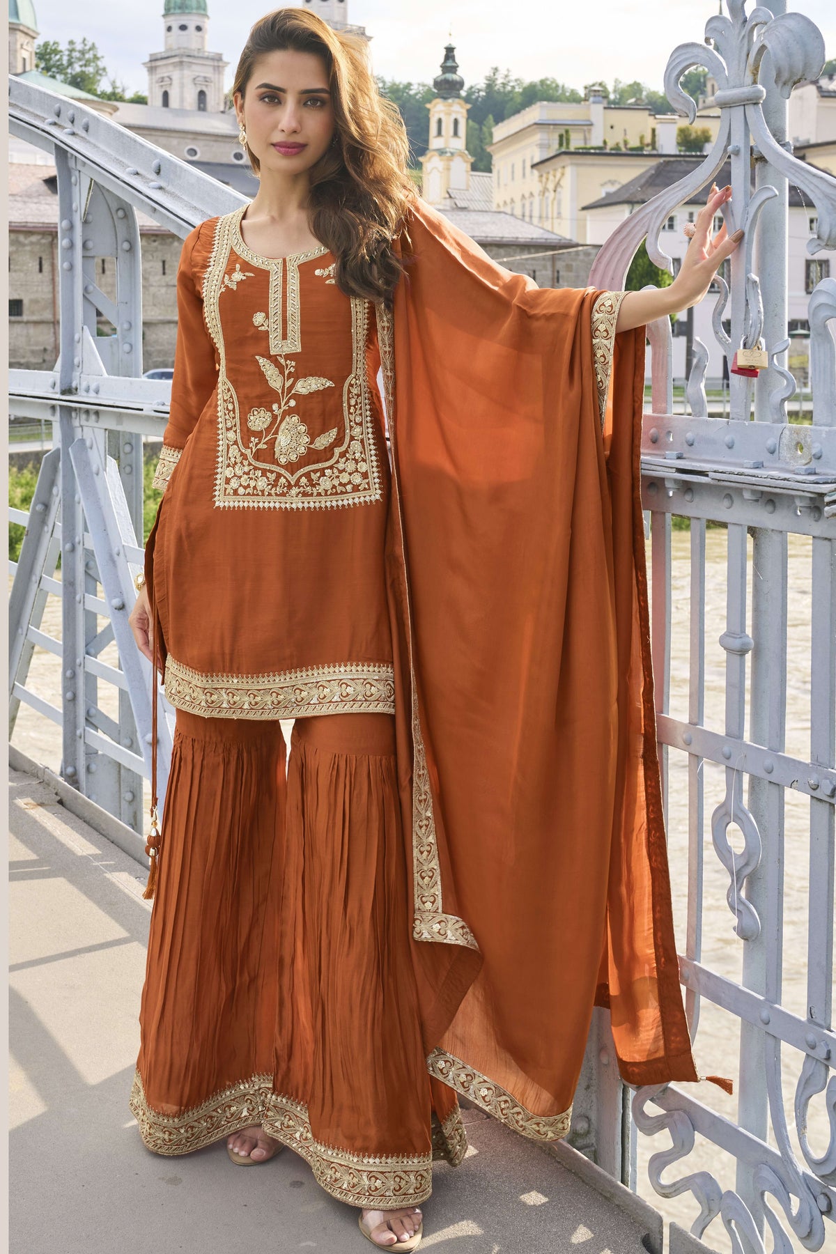 Rust sharara suit with embroidery work on pure silk, shown in a full front view of the kurta, sharara and dupatta.