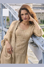Model wearing a Beige sharara suit with embroidered pure silk kurta and dupatta, full-length side view.