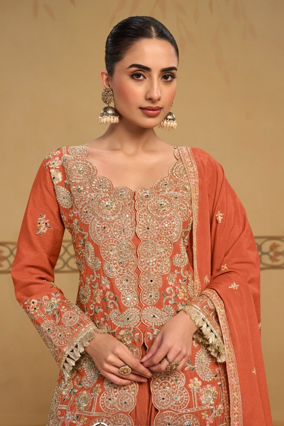 Close-up view of the neckline embroidery of the Rust palazzo suit, showing the embroidered neckline and sleeve detailing on chinon silk.