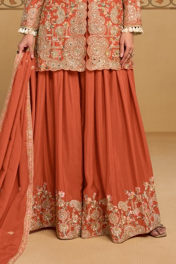 Waist-down view of the palazzo and kameez hem of the Rust indian palazzo suit, displaying the flared palazzo and embroidered kameez hem.