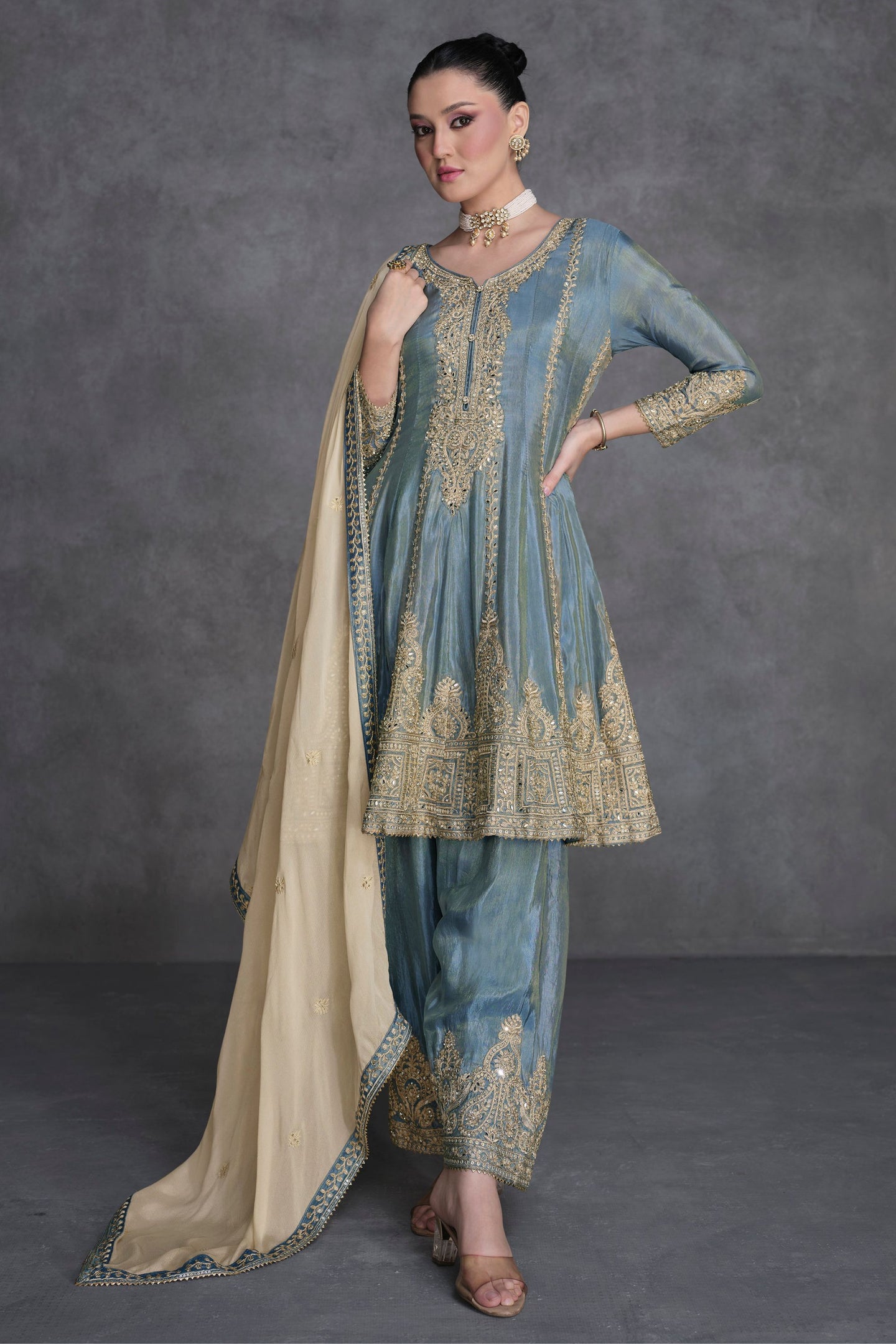A woman modeling a grey organza kameez with embroidery work and a matching pant, suitable for Indian festivals and Pakistani weddings.