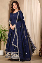 Woman wearing navy blue anarkali dress for wedding in art silk with sequin and thread embroidery, crepe churidar and embroidered dupatta, full-length front view.