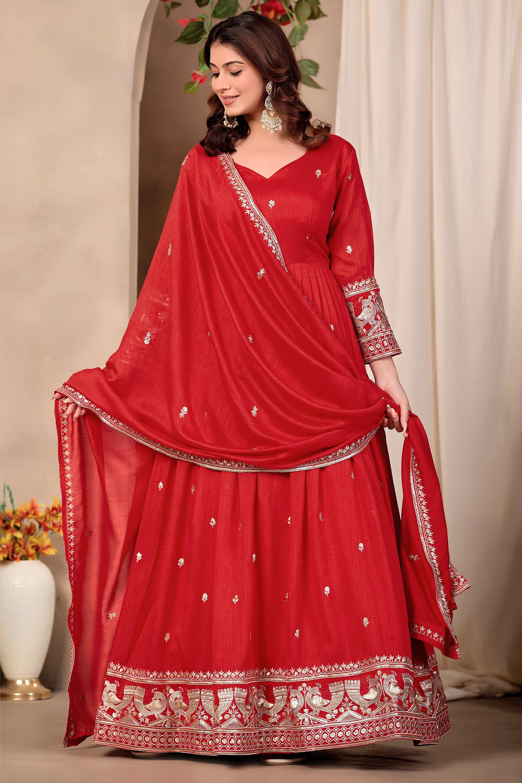 Woman wearing red indian wedding guest dresses style anarkali suit in art silk with sequin and thread embroidery, crepe churidar and embroidered dupatta, full-length front view.