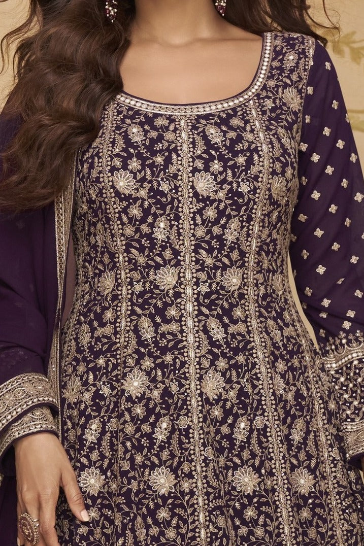 Neckline-to-waist close view of a purple anarkali gown for wedding in georgette with heavy gold zari embroidery and full sleeves.