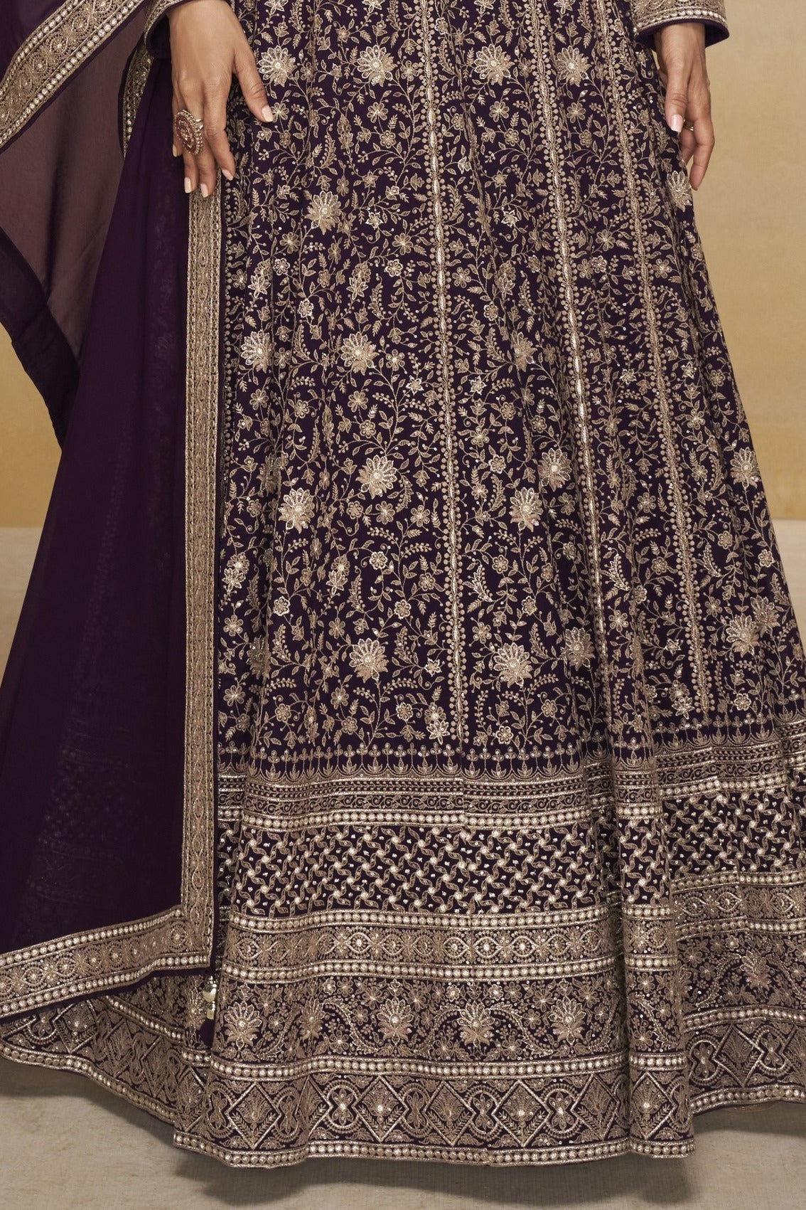 Waist-to-hem view of a purple georgette anarkali dress with gold zari floral embroidery, wide embroidered border and matching dupatta.