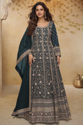 Woman wearing a teal anarkali gown in georgette with all-over gold zari embroidery and matching dupatta, full-length front view.