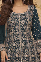 Neckline-to-waist close view of a teal wedding anarkali dress in georgette with heavy gold zari embroidery and full sleeves.