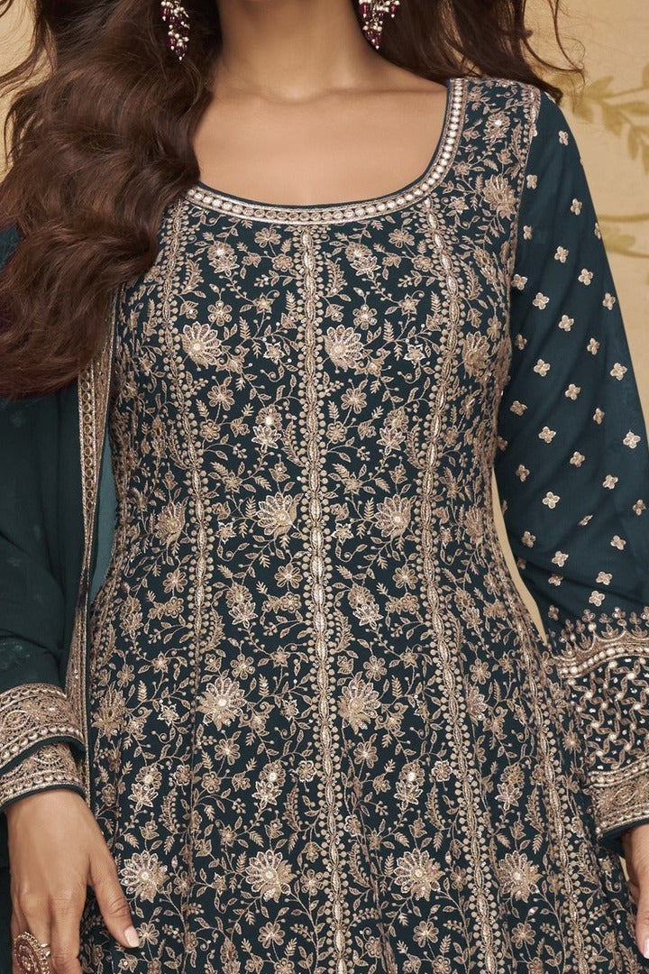Neckline-to-waist close view of a teal wedding anarkali dress in georgette with heavy gold zari embroidery and full sleeves.