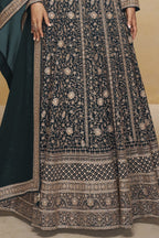 Waist-to-hem view of a teal pakistani anarkali suit in georgette with gold zari floral embroidery and wide embroidered hem border.