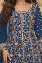 Neckline-to-waist close view of a blue anarkali suit for wedding in georgette with heavy gold zari embroidery and full sleeves.