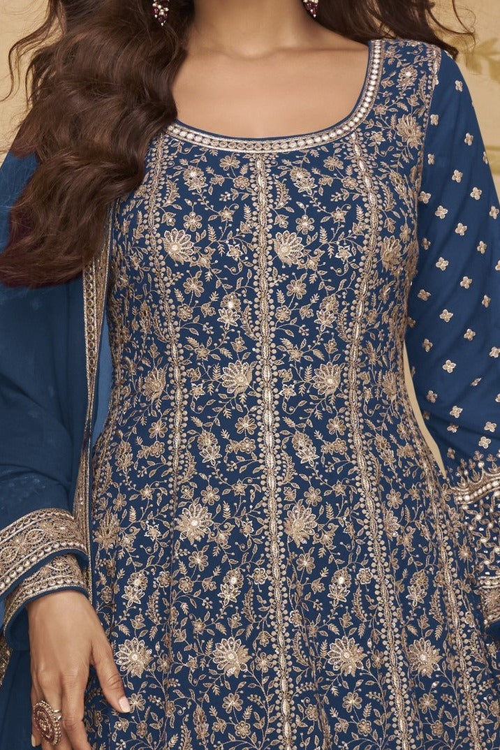 Neckline-to-waist close view of a blue anarkali suit for wedding in georgette with heavy gold zari embroidery and full sleeves.
