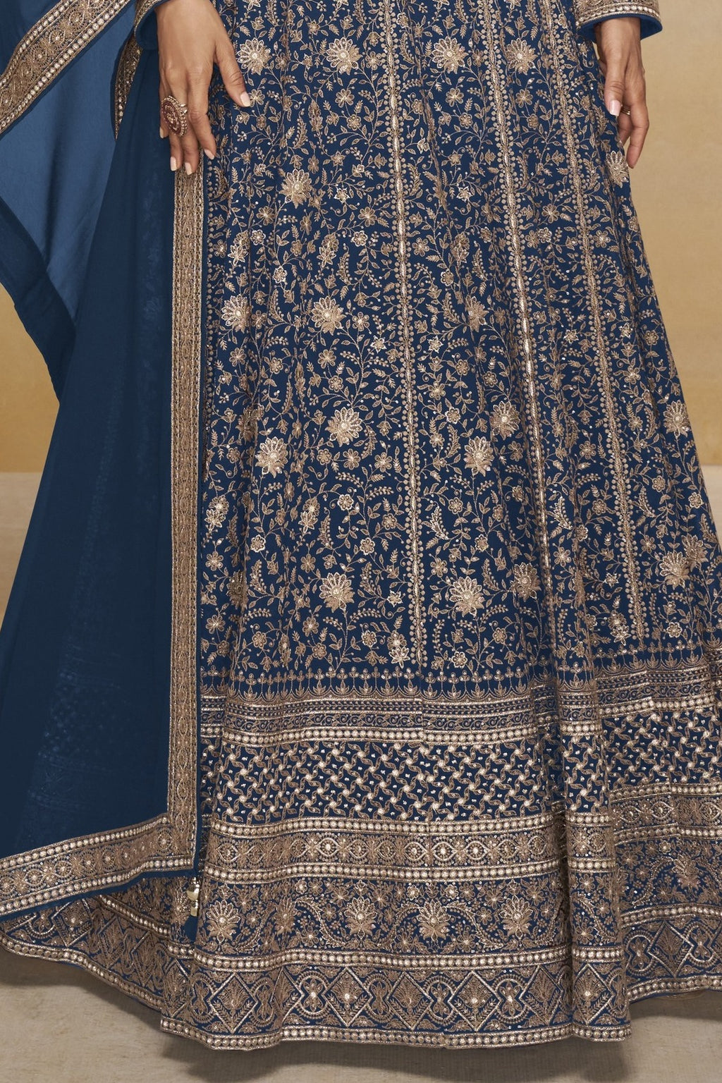 Waist-to-hem view of a blue georgette anarkali dress with gold zari floral embroidery, wide embroidered border and matching dupatta.