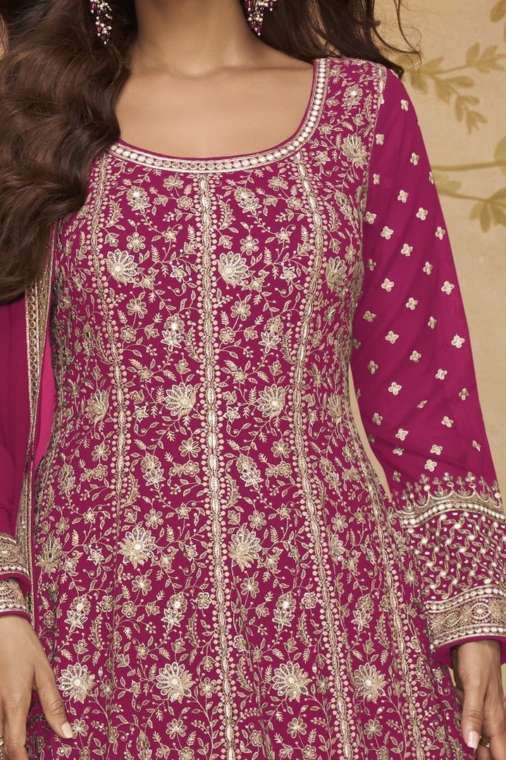 Neckline-to-waist close view of a dark pink wedding anarkali dress in georgette with heavy gold zari embroidery and full sleeves.