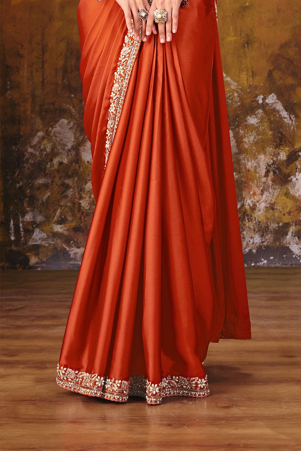 Rust party wear saree lower drape closeup showing border embroidery
