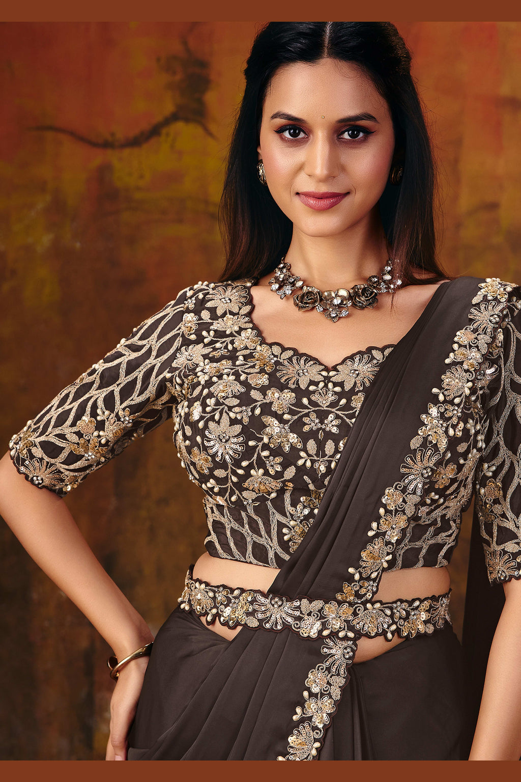 Dark brown embroidered saree blouse closeup with sequin and pearl work