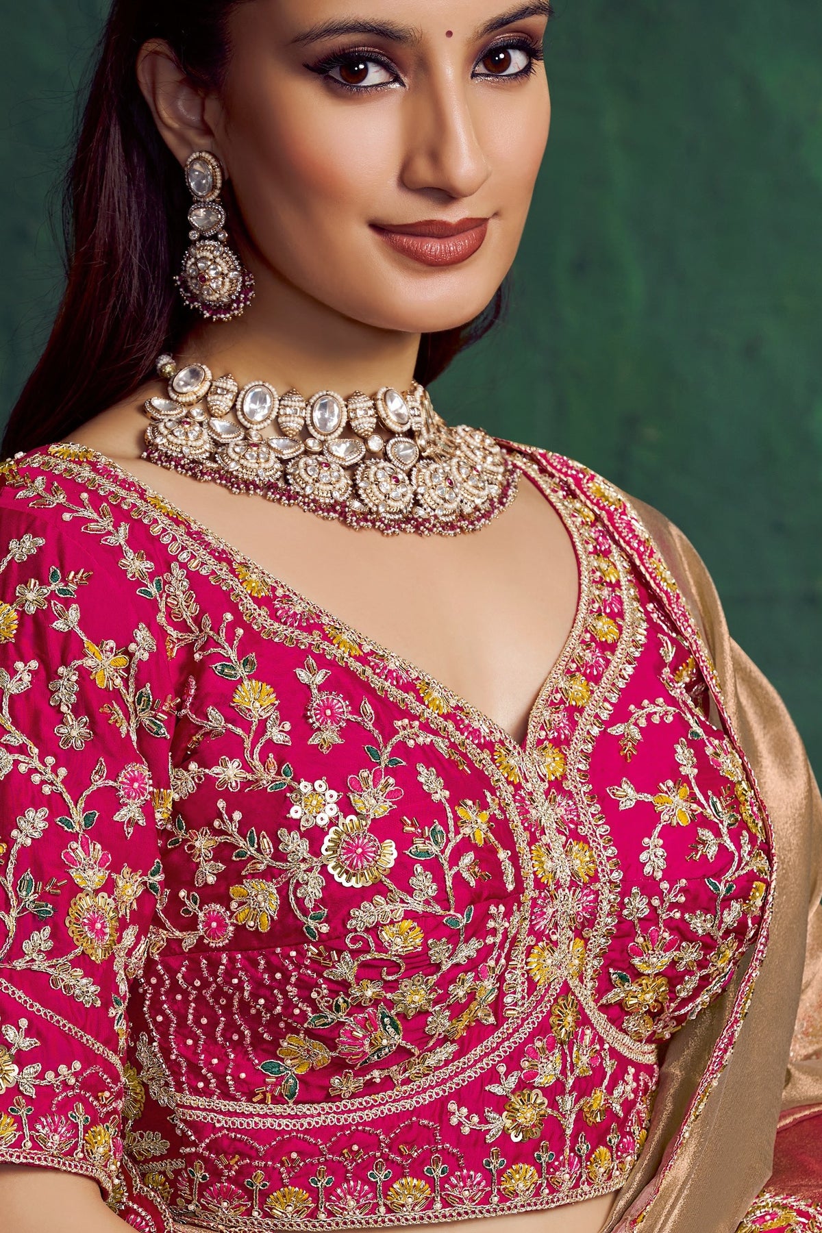 Hot pink designer saree, upper-body closeup of the bead work on the blouse and embroidered border