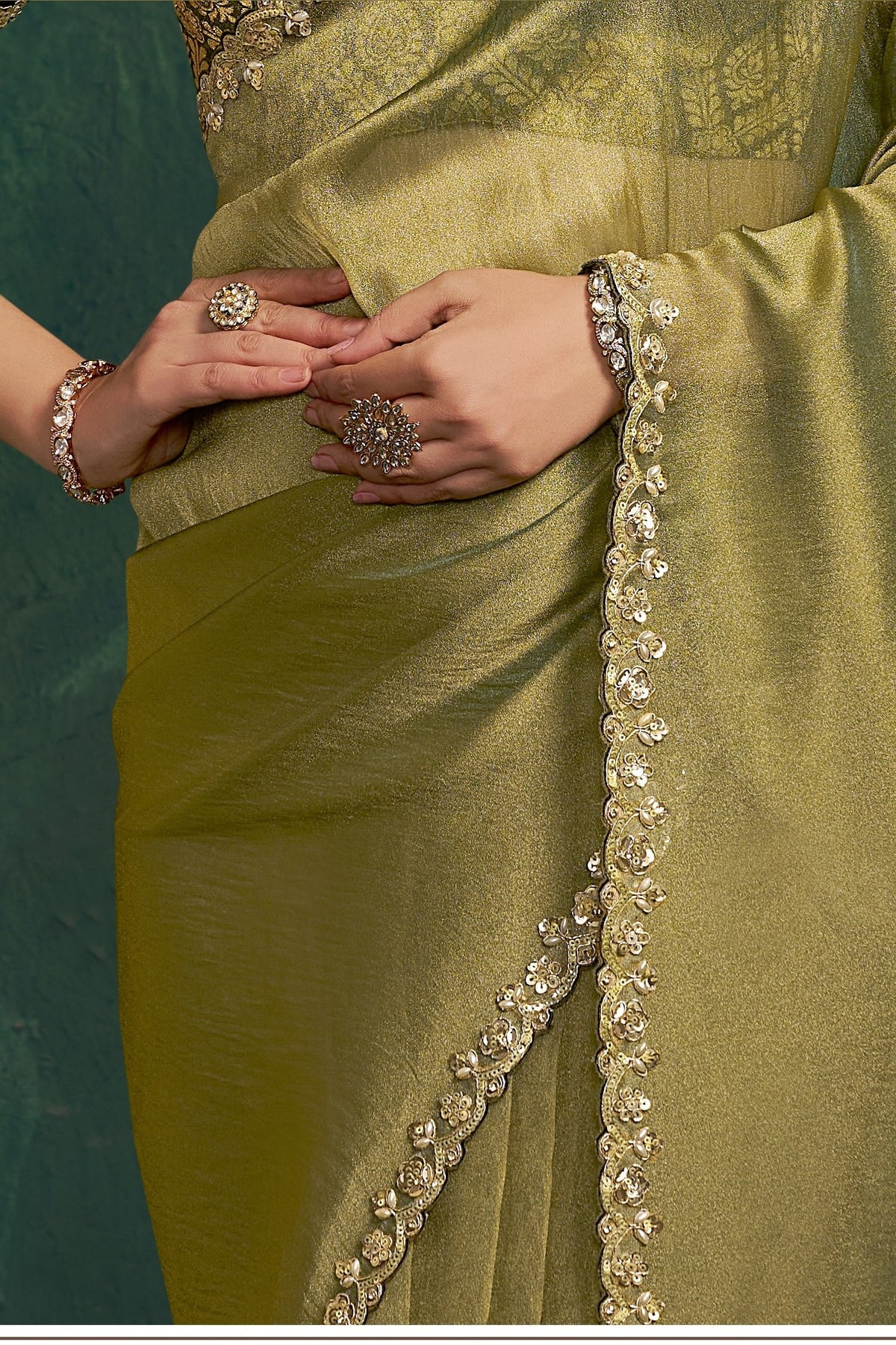 Olive green designer saree, waist-down view of the pleats and shimmering drape