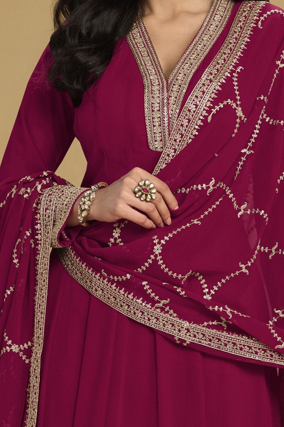 Torso detail view of a reddish pink indian salwar kameez in georgette with thread and sequin embroidery on the kurta and dupatta.