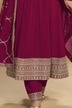 Waist-down detail view of a reddish pink wedding salwar kameez in georgette with thread and sequin embroidery on the kurta hem and pant.