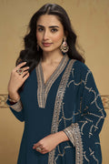 Woman wearing a dark teal kurta set in georgette with thread and sequin embroidery, georgette pant and dupatta, full-length front view.